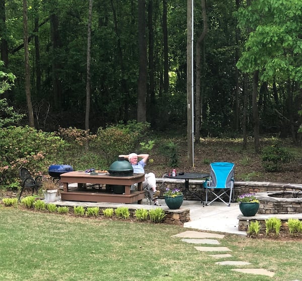 Bill Hollis, the author’s uncle, lounges alongside his Big Green Egg in what his son describes as his “outdoor man cave.” FAMILY PHOTO