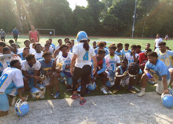 Atlanta School District Superintendent Meria Carstarphen, nursing a bum leg, addresses the Mays High School football team during a 2017 practice. Photo by Bill Torpy