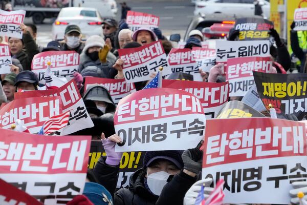 Supporters for impeached South Korean President Yoon Suk Yeol stage a rally against his impeachment near the Seoul Central District Court in Seoul, South Korea, Tuesday, Dec. 17, 2024. The signs read "Oppose the impeachment and Arrest opposition Democratic Party leader Lee Jae-myung." (AP Photo/Ahn Young-joon)