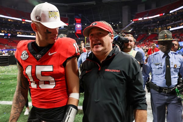 Georgia quarterback Carson Beck (15) and Georgia head coach Kirby Smart walk off of the field after their 22-19 overtime win against Texas during the 2024 SEC Championship game at Mercedes-Benz Stadium, Saturday, December 7, 2024, in Atlanta. Jason Getz / AJC)
