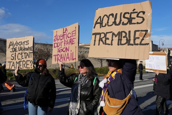 Activists hold posters during a women's rights demonstration, Saturday, Dec. 14, 2024 in Avignon, southern France, where the trial of dozens of men accused of raping Gisèle Pelicot while she was drugged and rendered unconscious by her husband is taking place. (AP Photo/Aurelien Morissard)