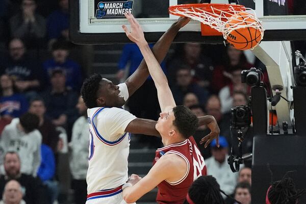 Kansas forward Flory Bidunga, left, dunks against Arkansas forward Zvonimir Ivisic (44) during the first half in the first round of the NCAA college basketball tournament, Thursday, March 20, 2025, in Providence, R.I. (AP Photo/Charles Krupa)