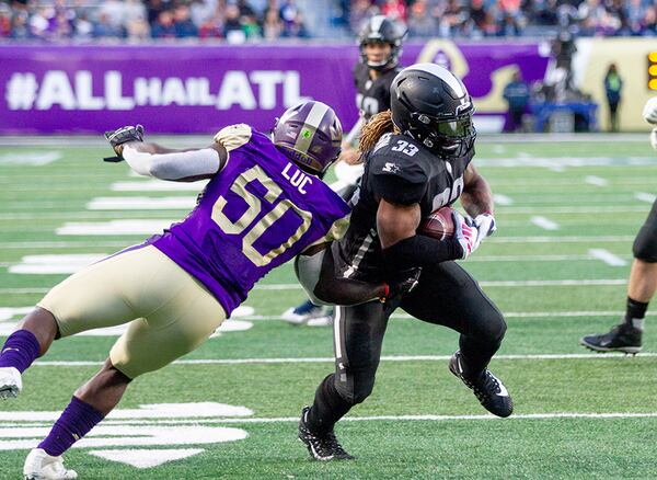 Birmingham Iron's Trent Richardson runs past Atlanta Legends' Jeff Luc on his way to the end zone Sunday, Feb. 24, 2019, at  Georgia State Stadium in Atlanta.