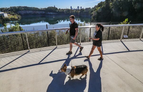 Joel Bouy (left) and Vi Bouy walk their dog, Yoshi, past the reservoir at Westside Reservoir Park in Atlanta. City Council passed legislation Monday to rename Westside Reservoir Park to Shirley Clarke Franklin Park. (John Spink/AJC 2021)