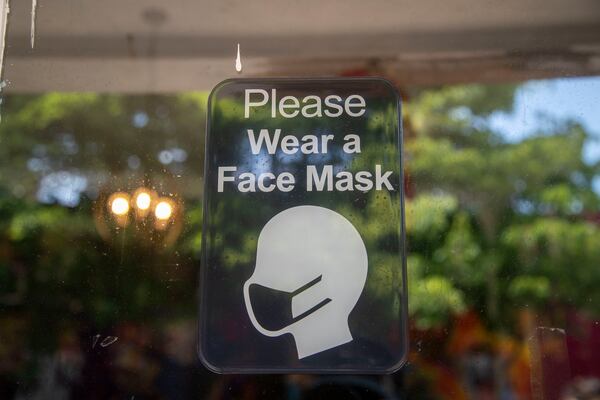 A sign asks customers to wear a mask at the vintage clothing store Drugstore Atlanta in Little Five Points in Atlanta. (Alyssa Pointer/Atlanta Journal Constitution)