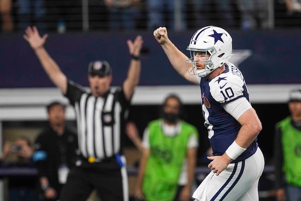 Dallas Cowboys quarterback Cooper Rush (10) celebrates after running back Rico Dowdle (23) ran for a touchdown against the New York Giants during the second half of an NFL football game in Arlington, Texas, Thursday, Nov. 28, 2024. (AP Photo/Tony Gutierrez)