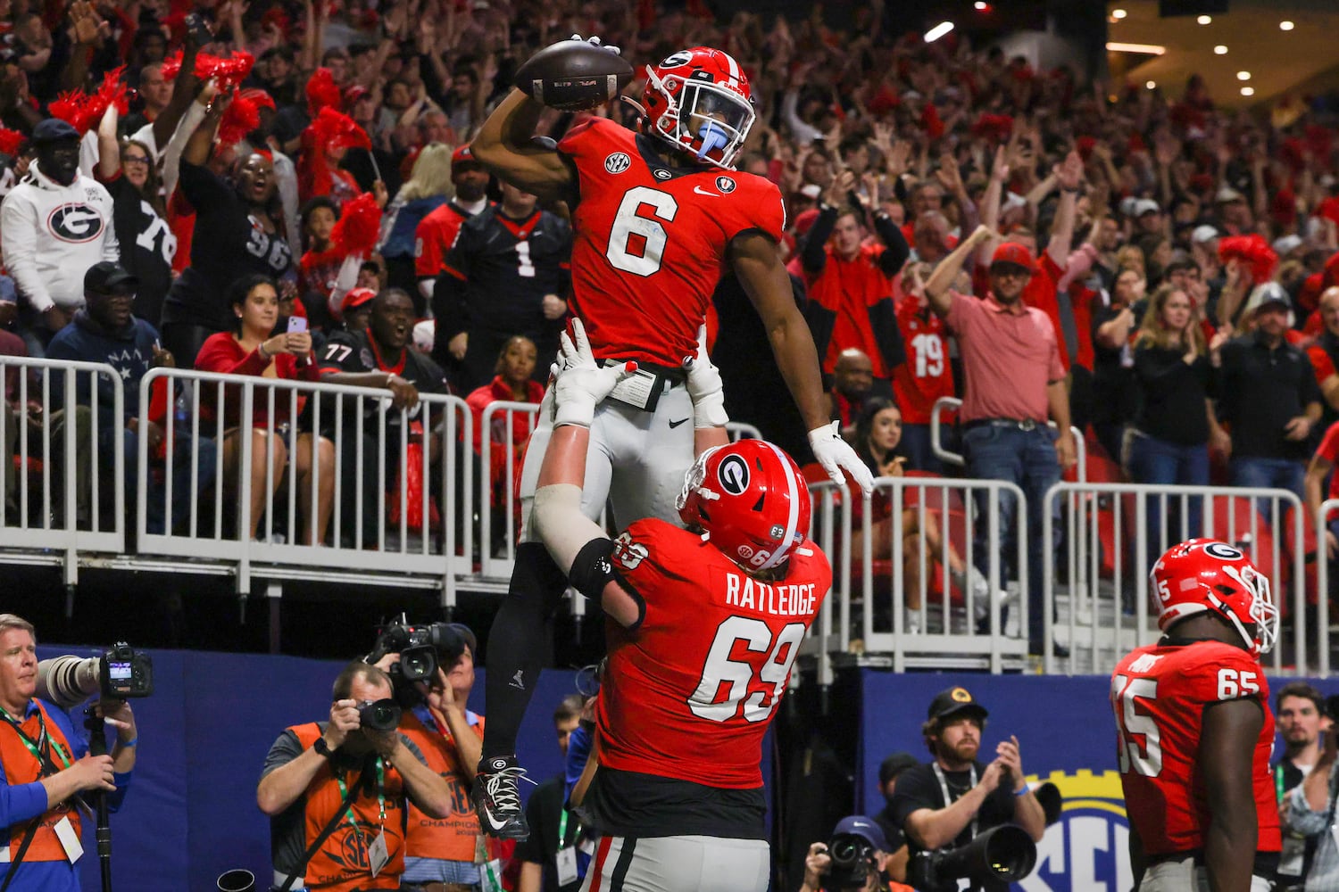 Georgia Bulldogs running back Kenny McIntosh (6) celebrates with lineman Tate Ratledge (69) after a touchdown over the LSU Tigers during the second half of the SEC Championship Game at Mercedes-Benz Stadium in Atlanta on Saturday, Dec. 3, 2022. (Jason Getz / Jason.Getz@ajc.com)