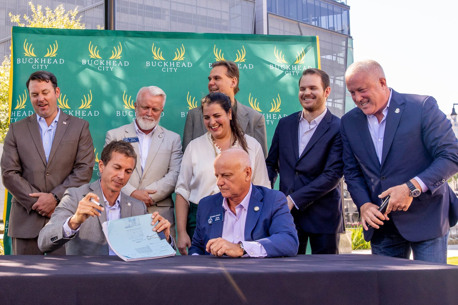 Buckhead City supporters, local residents and several state senators, including Greg Dolezal, seated, signed the bill in support of the city onsite, illustrating support in the state Senate, with the bill’s writer Senator Brandon Beach, seated right, at Loudermilk Park on Wednesday, Sept 29, 2021. The group announced that during the upcoming special legislative session the bill will be discussed.    (Jenni Girtman for The Atlanta Journal-Constitution)