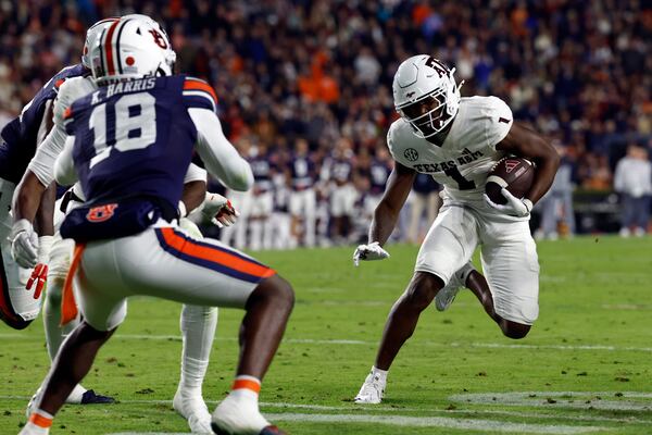 Texas A&M wide receiver Jabre Barber (1) carries the ball as Auburn safety Kaleb Harris (18) defends during the first half of an NCAA college football game, Saturday, Nov. 23, 2024, in Auburn, Ala. (AP Photo/Butch Dill)