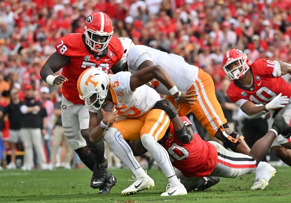 Tennessee quarterback Hendon Hooker is brought down by Georgia defensive lineman Tramel Walthour (90). (Hyosub Shin / Hyosub.Shin@ajc.com)