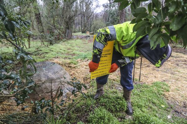 A DeKalb County Watershed worker posts sewage spill notifications on along Miriam Lane near Gena Drive in Decatur, where frequent sewage overflow occurrences have been cited. DeKalb County is still tackling ongoing sewer issues since CEO Michael Thurmond took over in 2017. DeKalb County is under a federal consent decree to repair its aging and overwhelmed wastewater system and has dedicated more than $300 million to the cause in recent years. JOHN SPINK/JSPINK@AJC.COM