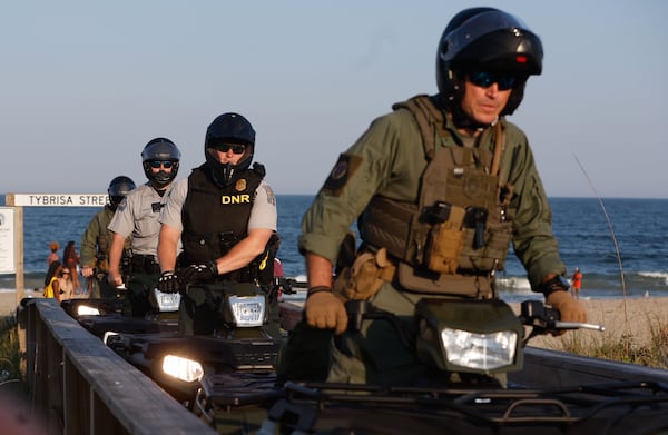 Georgia Department of Natural Resources law enforcement division patrol the beach on ATVs on Friday, April 19, 2024. The island put various traffic and safety protocols in place in anticipation of large crowds in town Orange Crush, an annual spring break gathering for college students. (Natrice Miller/ AJC)