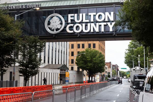 People walk out of the Fulton County Courthouse which is now surrounded by barricades on Thursday, August 10, 2023. (Michael Blackshire/Michael.blackshire@ajc.com)