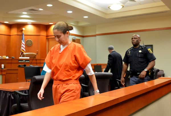 Andrea Sneiderman is escorted out of Dekalb County Superior Court on Dec. 12, 2013 following a bond hearing. Sneiderman was convicted of perjury for lying under oath in the shooting death of her husband. KENT D. JOHNSON / KDJOHNSON@AJC.COM