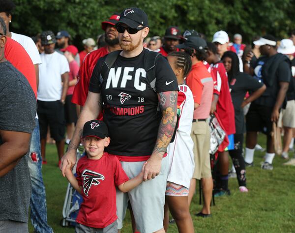 Falcons fan David Pope sports a NFC Champions shirt waiting in line with his son Samuel, 4, Woodstock, for the first day of team practice at training camp on Thursday, July 27, 2017, in Flowery Branch.