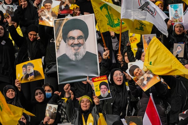 Mourners react as a trailer carrying the coffins containing the bodies of Hezbollah's former leader Hassan Nasrallah and his cousin and successor Hashem Safieddine drives through the crowd at the beginning of a funeral procession in the Sports City Stadium in Beirut, Lebanon, Sunday, Feb. 23, 2025. (AP Photo/Hussein Malla)