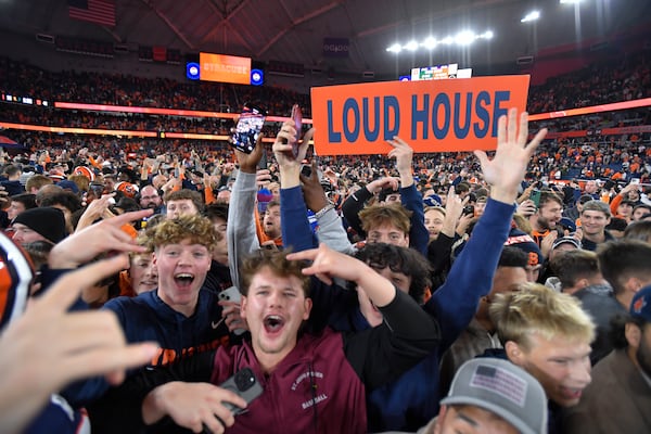 Syracuse fans stormed the field after the team's win against Miami in an NCAA football game on Saturday, Nov. 30, 2024 in Syracuse, N.Y. (AP Photo/Adrian Kraus)