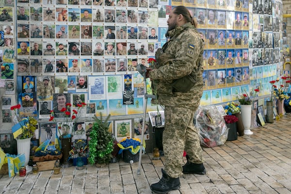 A serviceman mourns at the Memorial Wall of Fallen Defenders of Ukraine in Russian-Ukrainian War in Kyiv, Ukraine, Monday, Feb. 24, 2025. (AP Photo/Andrew Kravchenko)