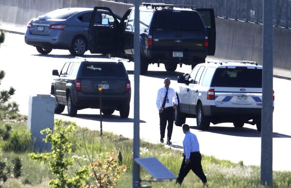 Denver Police Department detectives, foreground, investigate the scene where a Nissan sedan, top left, driven by Uber driver Michael Hancock crashed into a retaining wall along Interstate 25 near downtown Denver early Friday, June 1, 2018. Hancock, 29, is accused of shooting and killing a passenger at 2:45 a.m. after a confrontation broke out between the two men while headed southbound on the interstate.