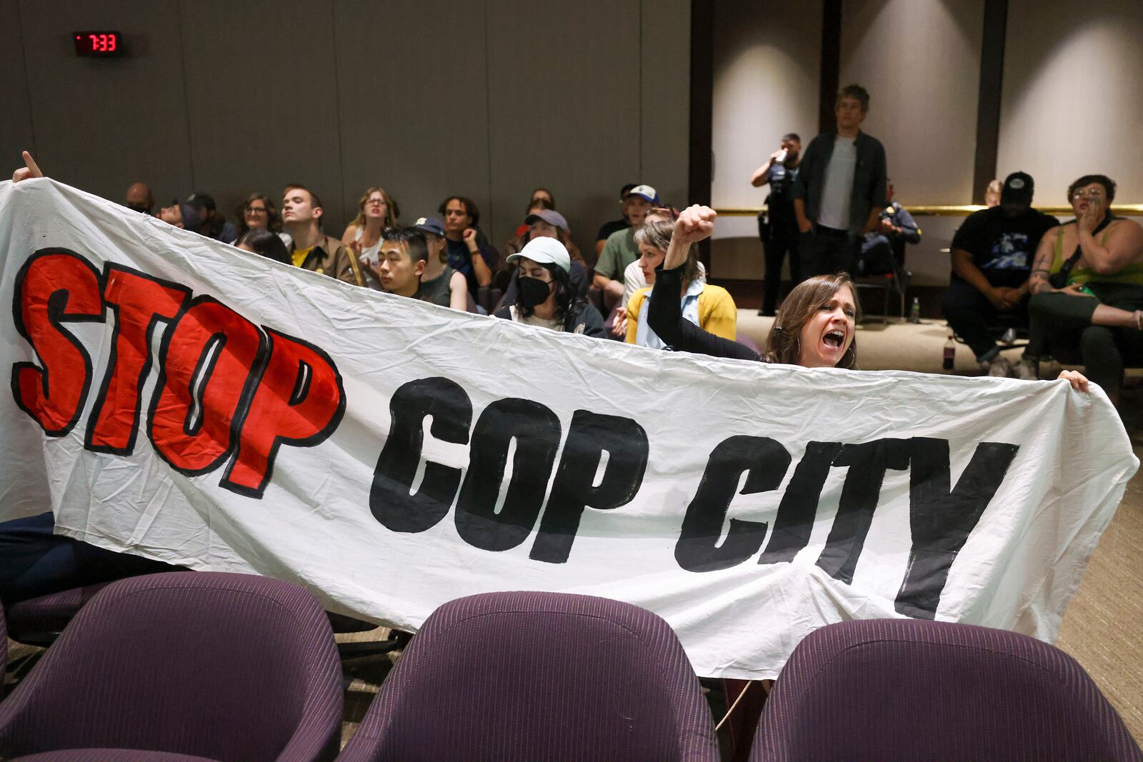 Protestors hold a banner and shout, "Stop Cop City," during the public comment portion of the Atlanta City Council ahead of the final vote to approve legislation to fund the training center at Atlanta City Hall, on Monday, June 5, 2023, in Atlanta. (Jason Getz/The Atlanta Journal-Constitution/TNS)