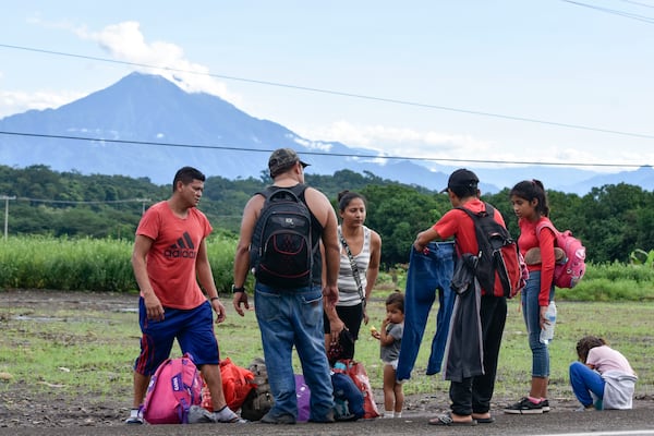 Migrants pause on the shoulder of a road, on the outskirts of Tapachula, Chiapas state, Mexico, Wednesday, Nov. 20, 2024, during their journey to the U.S. border. (AP Photo/Edgar H. Clemente)