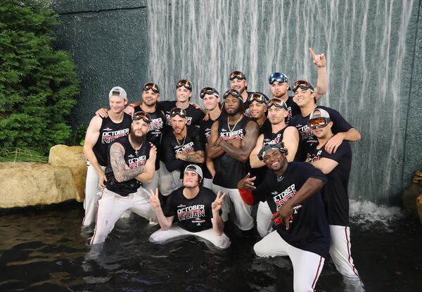 Braves players take a dip in the outfield water feature. (Curtis Compton/ccompton@ajc.com)