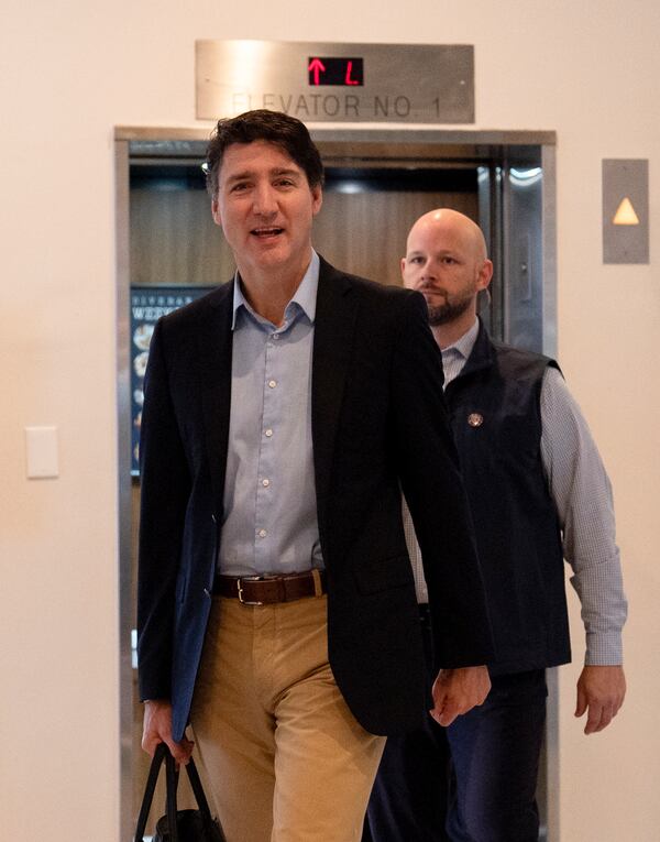 Canada Prime Minister Justin Trudeau briefly speaks to media as he walks through the lobby of the Delta Hotel by Marriott, Saturday, Nov. 30, 2024, in West Palm Beach, Fla. (AP Photo/Carolyn Kaster)