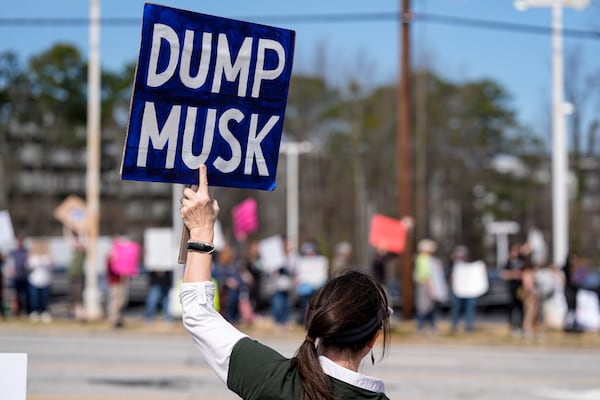 Korinna Hirsch stands with other demonstrators during a protest of automaker billionaire CEO, Elon Musk near a Tesla vehicle dealership, Saturday, March 8, 2025, in Decatur, Ga. (AP Photo/Mike Stewart)