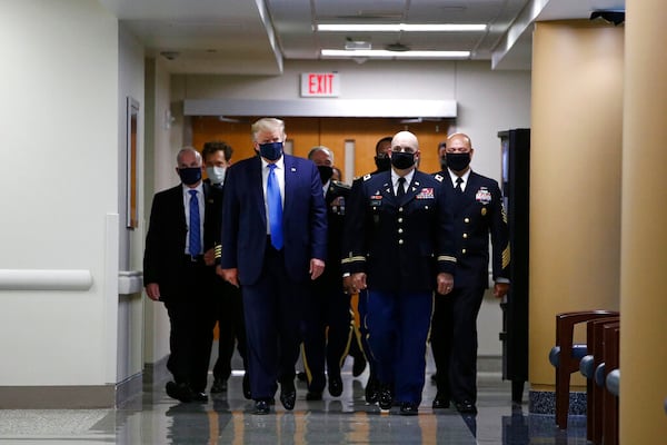 President Donald Trump wears a face mask as he walks down a hallway during a visit to Walter Reed National Military Medical Center in Bethesda, Md., Saturday, July 11, 2020. (AP Photo/Patrick Semansky)