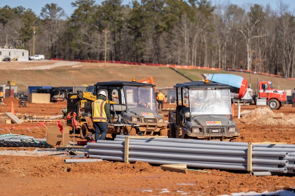 Construction workers move supplies in a muddy work area  at the home of the United States Soccer Federation on Tuesday, January 14, 2024, in Atlanta, at U.S. Soccer Federation Headquarters in Fayette, Georgia. (Atlanta Journal-Constitution/Jason Allen)