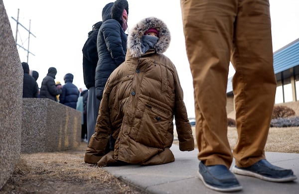 FILE - A child, bundled against the cold, stands in line to attend an immigration registration meeting outside of the U.S. Immigration and Customs Enforcement office in Cedar Rapids, Iowa, Feb. 4, 2025. (Jim Slosiarek/The Gazette Via AP, File)