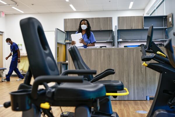 Physical therapist Maurice Middleton (left) and occupational therapist Yewande Oso (right) prepare the physical therapy room for patients at the Cobb County Veteran Affairs Clinic in Marietta on Monday, September 26, 2022. (Natrice Miller/natrice.miller@ajc.com)  