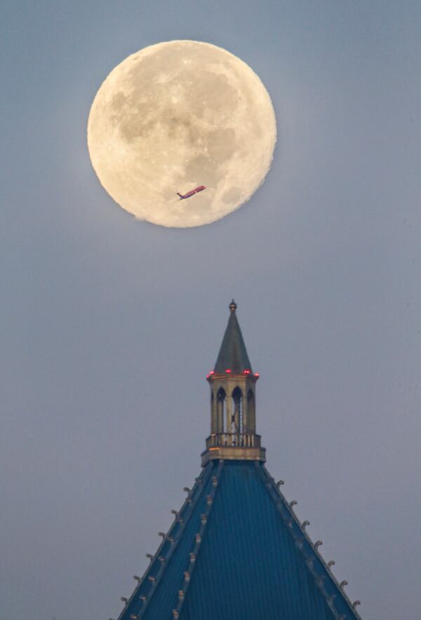 The April full moon may not be as spectacular this one, photographed over Atlanta November 15, 2016.  A plane moves across the supermoon over One Atlantic Center in Atlanta on Tuesday, Nov. 15, 2016.. JOHN SPINK /JSPINK@AJC.COM