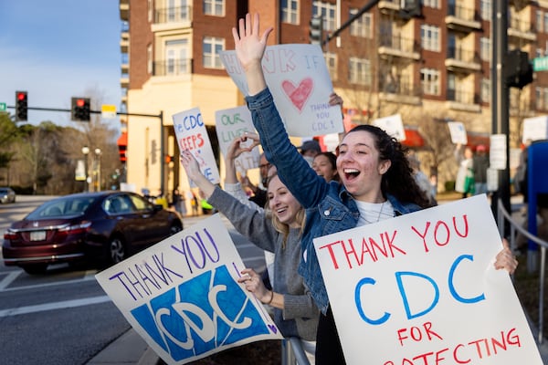 Emory public health students cheer in support of employees at the Centers for Disease Control and Prevention in Atlanta as they leave work on Tuesday. Demonstrators had gathered to protest the recent mass firings there.