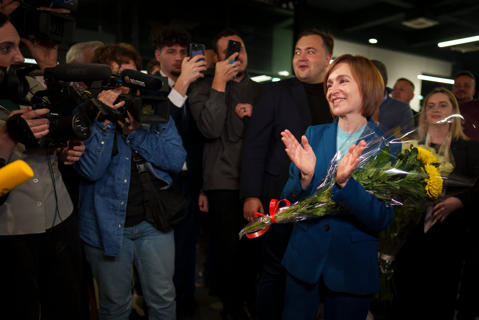 Moldova's President Maia Sandu celebrates with supporters as preliminary results are announced for the presidential election runoff in Chisinau, Moldova, late Sunday, Nov. 3, 2024. (AP Photo/Vadim Ghirda)