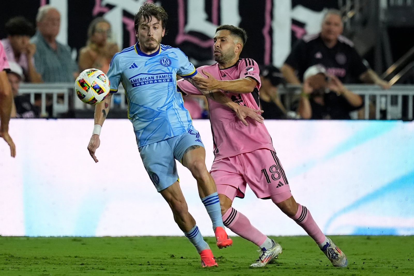 Inter Miami defender Jordi Alba (18) grabs Atlanta United midfielder Saba Lobzhanidze (9) during the first half of an MLS playoff soccer match, Friday, Oct. 25, 2024, in Fort Lauderdale, Fla. (AP Photo/Rebecca Blackwell)