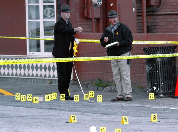 Violence wasn't unusual in the old Buckhead Village. Atlanta Homicide Detectives, Mark Cooper (left) and J.K. Brown stand amid a field of shells during an investigation into a 2004 shooting in which two men were killed. PHOTO: JOHN SPINK