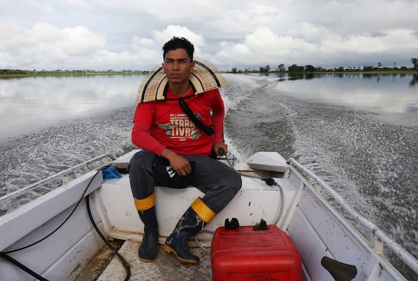 Indigenous leader Filipe Gabriel Mura maneuvers a boat through the territory of the Mura people, in the Lago do Soares village, in Autazes, Amazonas state, Brazil, Tuesday, Feb. 18, 2025. (AP Photo/Edmar Barros)