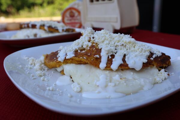 Cachapas are Venezuelan corn pancakes, cooked on a griddle, crisp on the edges and soft in the middle. This one is filled with chicken and cheese, then topped with more cheese. 
Miguel Martinez / miguel.martinezjimenez@ajc.com