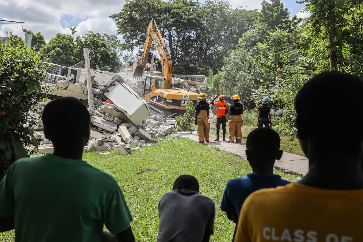 Firefighters and emergency personnel survey buildings damaged during an earthquake near Camp-Perrin, Haiti, on Sunday, Aug, 15, 2021. (Valerie Baeriswyl/The New York Times)