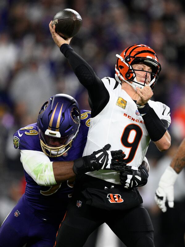 Baltimore Ravens linebacker Odafe Oweh, left, pressures Cincinnati Bengals quarterback Joe Burrow (9) as he passes the ball during the first half of an NFL football game, Thursday, Nov. 7, 2024, in Baltimore. (AP Photo/Nick Wass)