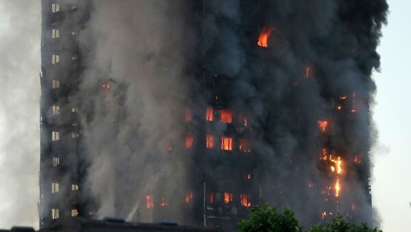 Smoke and flames rise from building on fire in London, Wednesday, June 14, 2017. Metropolitan Police in London say they're continuing to evacuate people from a massive apartment fire in west London. The fire has been burning for more than three hours and stretches from the second to the 27th floor of the building.(AP Photo/Matt Dunham)