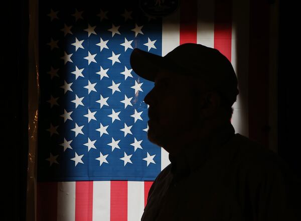 West works in a makeshift shop inside the garage of his Kennesaw home, which is decorated with American flags. Curtis Compton/ccompton@ajc.com