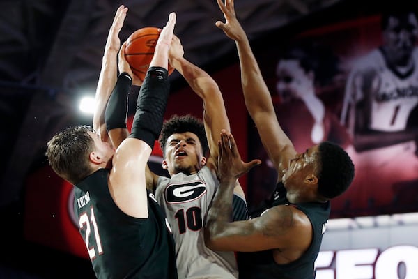 Georgia's Toumani Camara (10) is stoped by South Carolina forwards Maik Kotsar (21) and Keyshawn Bryant during an NCAA college basketball game Wednesday, Feb. 12, 2020, in Athens, Ga. (Joshua L. Jones/Athens Banner-Herald via AP)