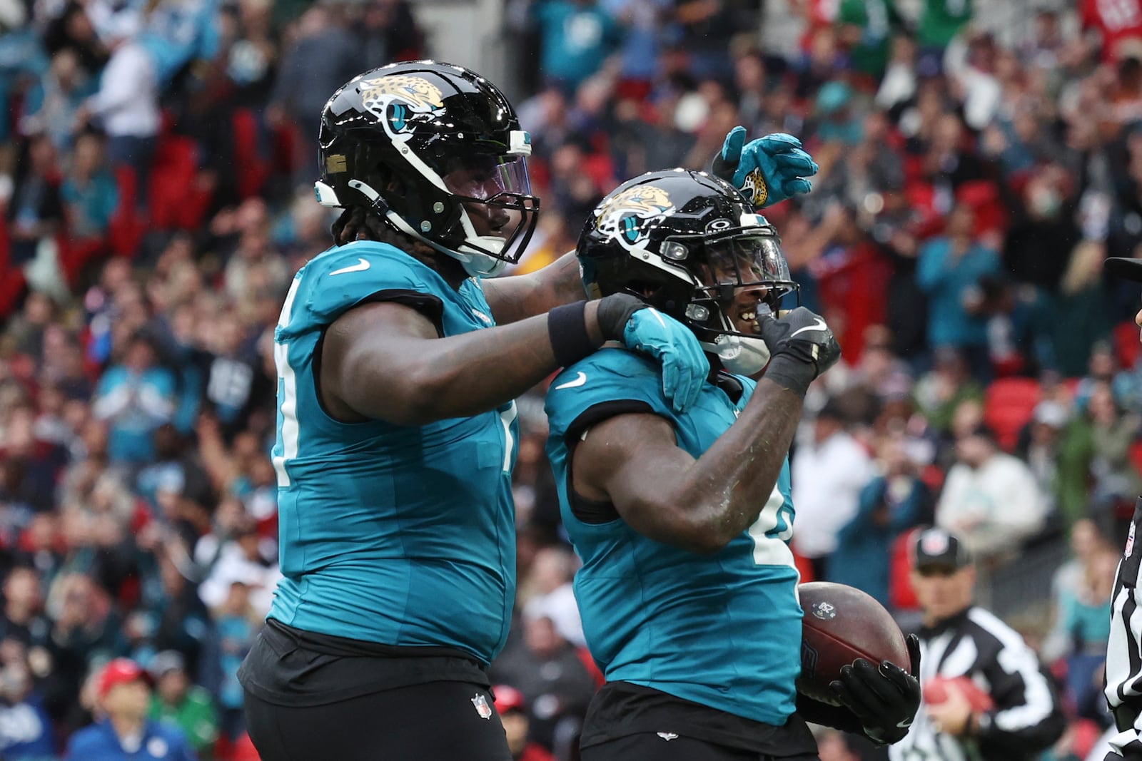 Jacksonville Jaguars running back Tank Bigsby, right, celebrates his 1-yard rushing touchdown during the first half of an NFL football game against the New England Patriots, Sunday, Oct. 20, 2024, in London. (AP Photo/Ian Walton)