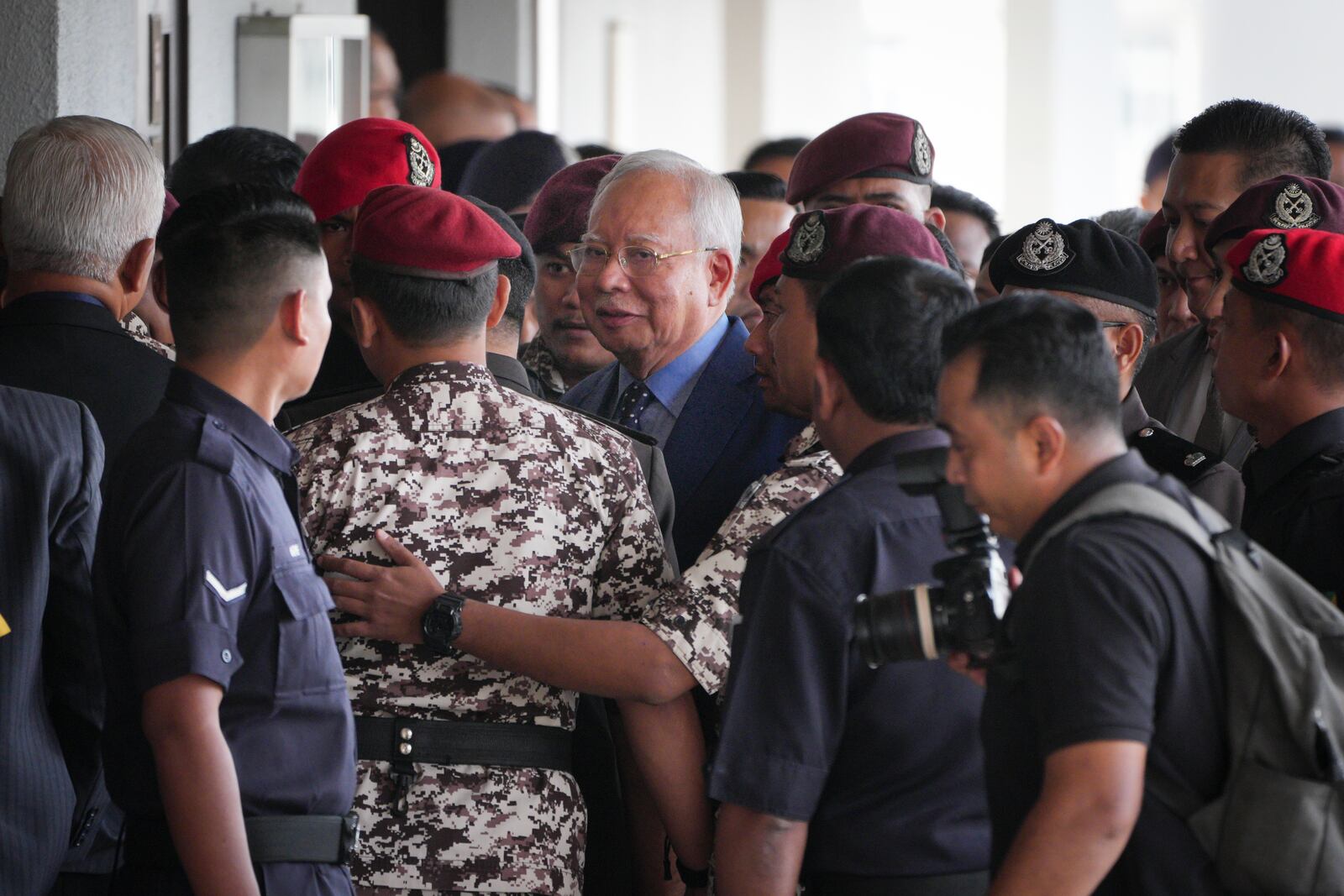 Malaysian former Prime Minister Najib Razak, center, is escorted by prison officers on his arrival at the Kuala Lumpur High Court complex in Kuala Lumpur, Malaysia Wednesday, Oct. 30, 2024. (AP Photo/Vincent Thian)