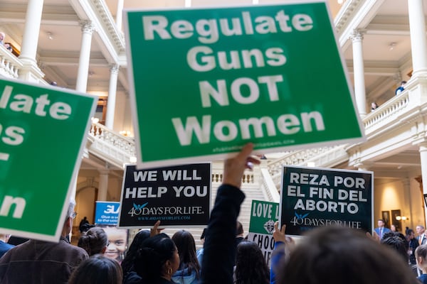 Pro-abortion activists and anti-abortion activists hold opposing signs at  the Georgia Capitol in Atlanta in 2023.