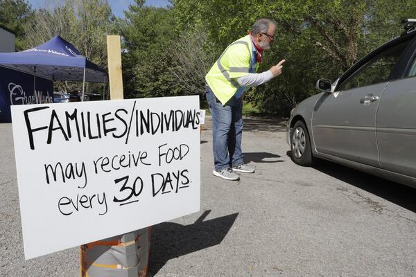 Greg Perry talks to a driver arriving at GraceWorks Ministries food pantry in Franklin, Tenn. In addition to finding ways to meet the spike in demand, food banks have had to devise creative new ways to distribute ever greater amounts of food while keeping both recipients and their staff safe from exposure to the coronavirus.