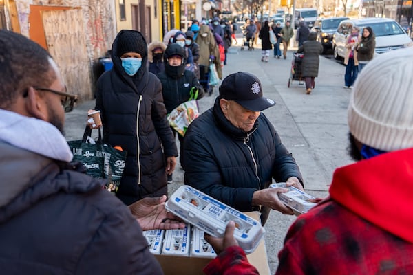 Abou Sow hands out cartons of eggs to people waiting in line to receive free eggs from FarmerJawn Agriculture, Friday, March 21, 2025, in the Harlem neighborhood of New York. (AP Photo/Julia Demaree Nikhinson)