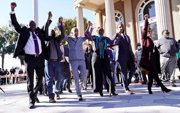 The Rev. Al Sharpton, third from the left, holds hands with Ahmaud Arbery‚Äôs parents, Wanda Cooper-Jones, right, and Marcus Arbery, left, as they react outside the Glynn County Courthouse in Brunswick, Ga., on Wednesday, Nov. 24, 2021, after the jury found three men guilty of murder and other charges for the pursuit and fatal shooting of Ahmaud Arbery. (Nicole Craine/The New York Times)